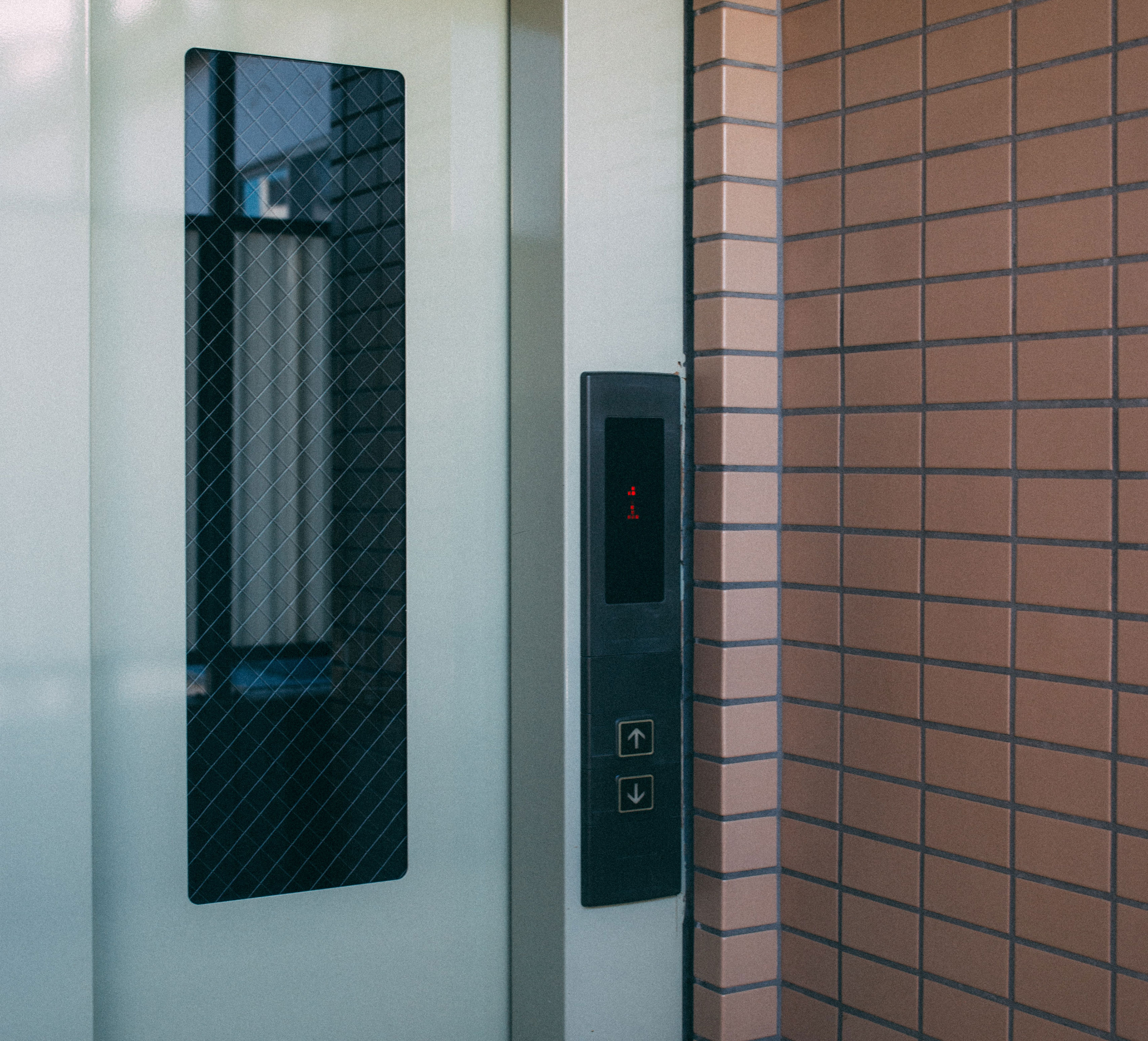 Rosh Elevators Lift Door with a black glass window on it and lift buttons on the wall.