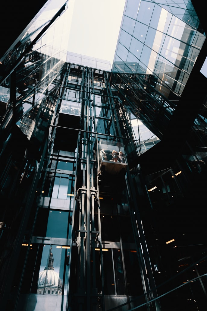 Working rosh elevators Lifts with a group of people in a glass type building.
